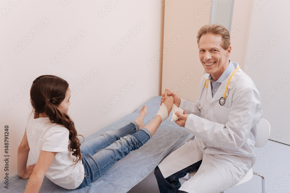 Diligent positive doctor wrapping girls foot in bondage Diligent positive doctor wrapping girls foot in bondage