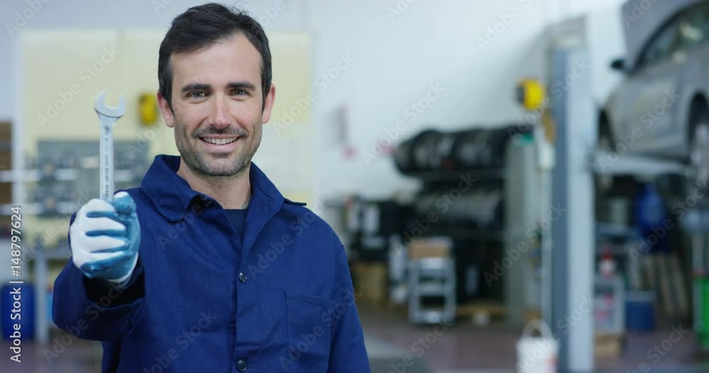 Portrait of a young beautiful car mechanic in a car workshop, in the background of a car service Concept repair of machines, fault diagnosis, repair specialist, technical maintenance on-board computer Portrait of a young beautiful car mechanic in a car workshop, in the background of a car service Concept repair of machines, fault diagnosis, repair specialist, technical maintenance on-board computer