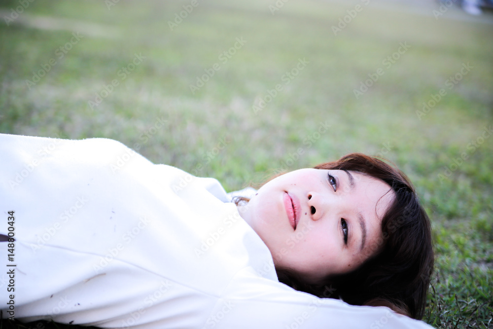 young attractive asian woman Lie on the lawn young attractive asian woman Lie on the lawn