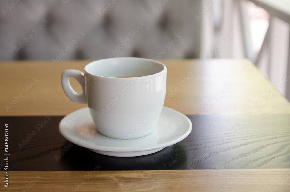 A cup of black coffee in a white cup on wooden background. A cup of black coffee in a white cup on wooden background.