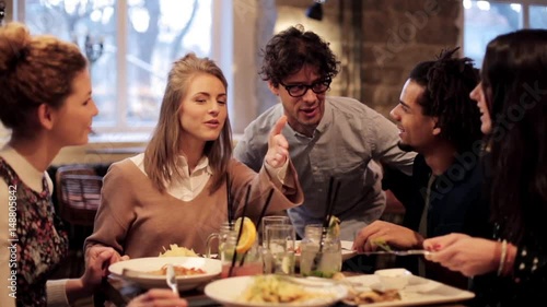 happy friends eating and drinking at restaurant