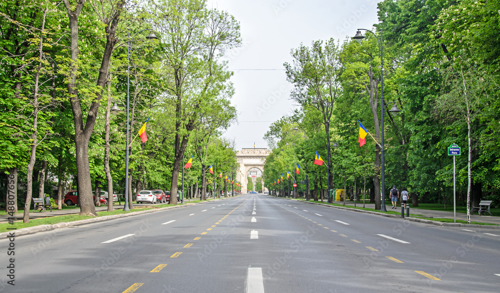 The Arch of Triumph (Arcul de Triumf) from Bucharest Romania, International Day with romanian flags, view from Kisseleff Avenue The Arch of Triumph (Arcul de Triumf) from Bucharest Romania, International Day with romanian flags, view from Kisseleff Avenue
