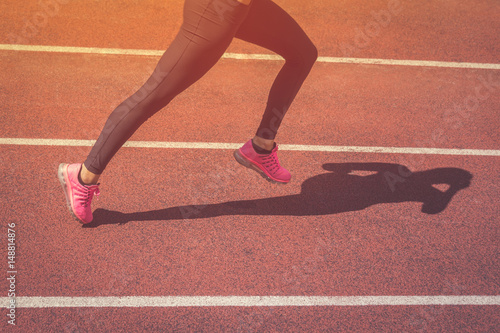 Close up of female jogger legs running on athletic track