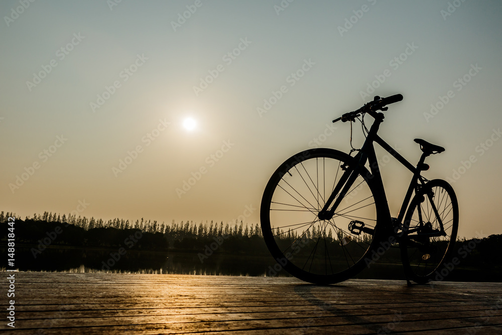 Fototapeta silhouette of bicycle near lake and Sunset on beautiful sky