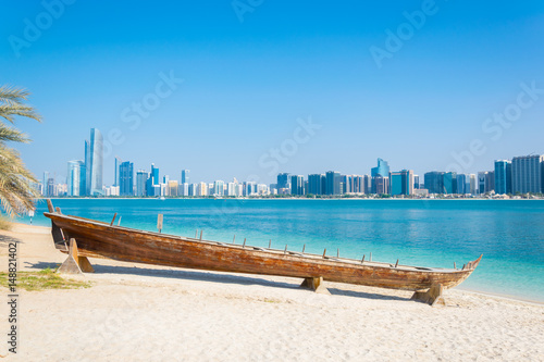 Wooden boat at the Heritage Village, in front of the Abu Dhabi skyline, United Arab Emirates photo