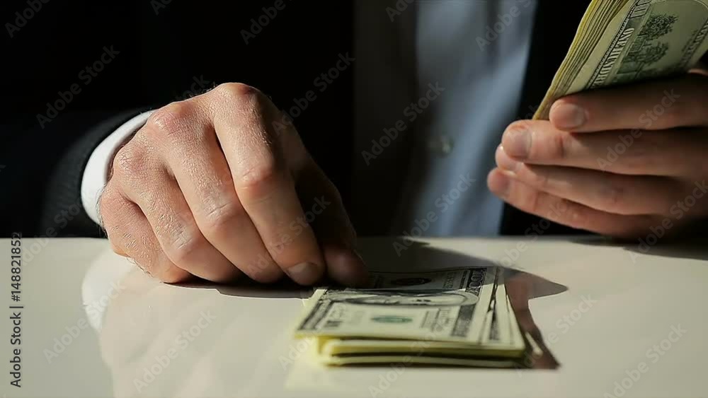 Close-Up Businessman Quickly Lays Out Hundred Dollar Bills on the Table Close-Up Businessman Quickly Lays Out Hundred Dollar Bills on the Table