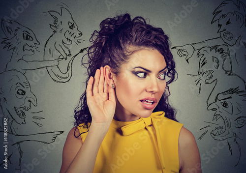 Fotografi woman holds her hand near ear and listens carefully to evil voices