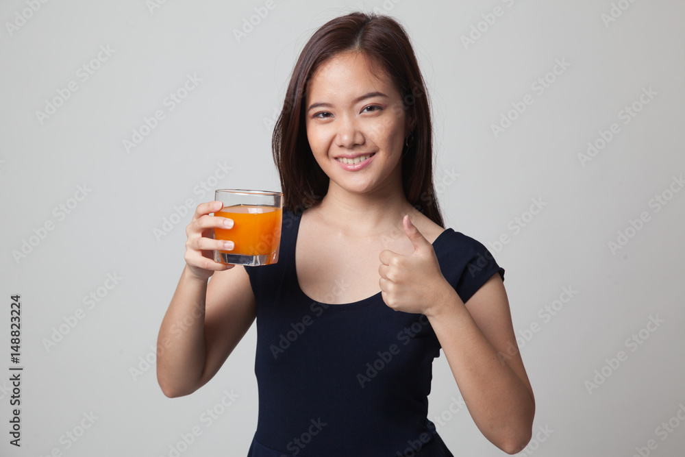 Young Asian woman thumbs up drink orange juice. Young Asian woman thumbs up drink orange juice.