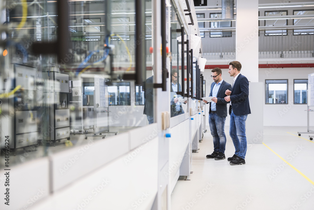 Two men with tablet in factory shop floor Two men with tablet in factory shop floor