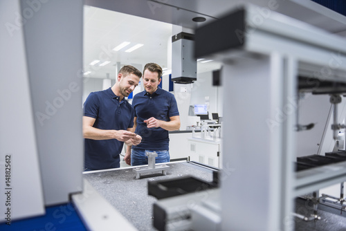 Two men at a machine in testing instrument room
