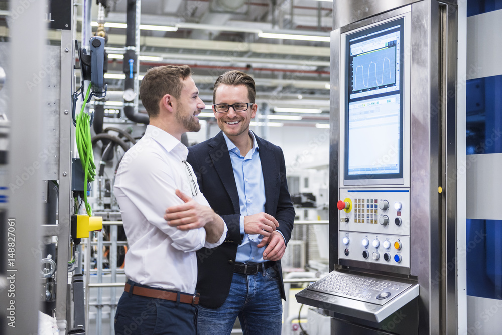 Two smiling men talking in factory shop Two smiling men talking in factory shop