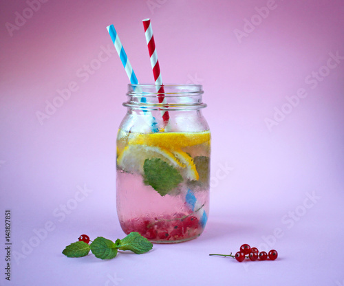 Fresh lemonade in a jar with red currant, lemon and mint