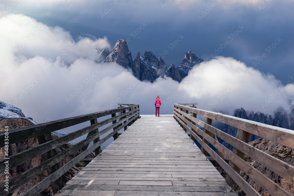 Obraz premium Solitude woman watching the mountains from boardwalk