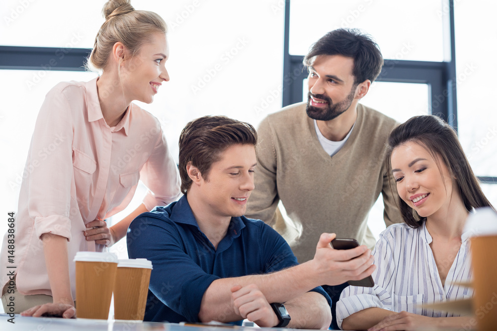 group of young business people using smartphone on small business meeting