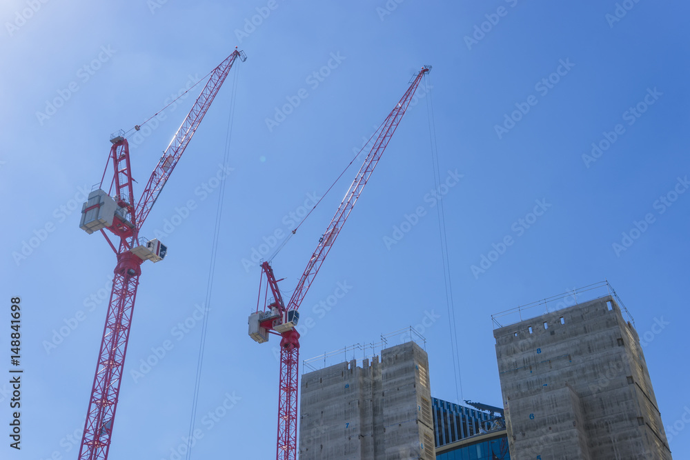 Tall cranes on building site.