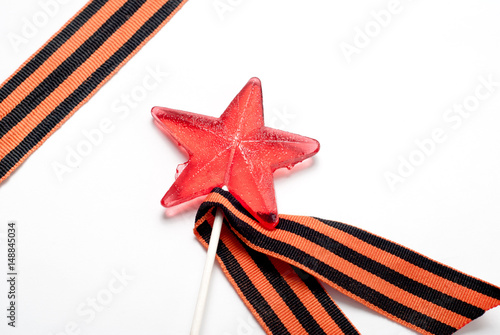 Candy in the shape of a star, a red candy on a stick, photo