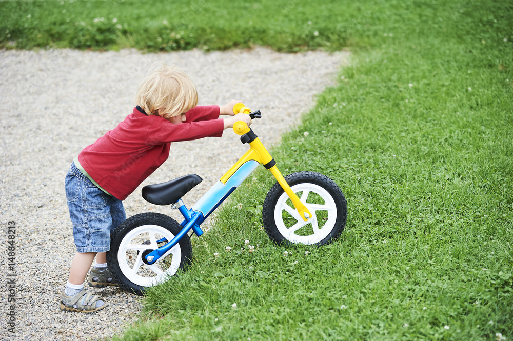 Happy toddler boy riding bike. Kids enjoying a bicycle ride. Sport concept. First bike for little child. Active toddler kid playing and cycling outdoors. Happy toddler boy riding bike. Kids enjoying a bicycle ride. Sport concept. First bike for little child. Active toddler kid playing and cycling outdoors.