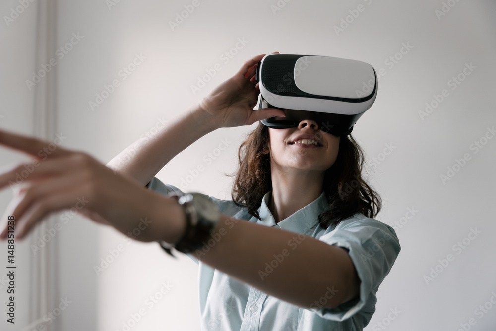 Portrait of happy smiling young beautiful girl, gain experience using VR-headset virtual reality glasses Portrait of happy smiling young beautiful girl, gain experience using VR-headset virtual reality glasses