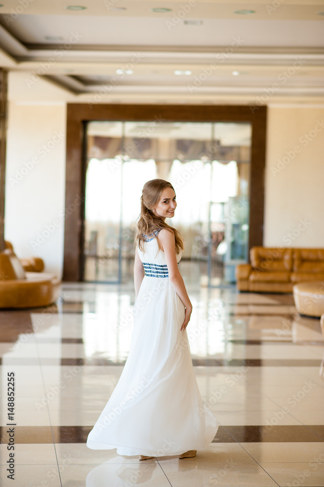Beautiful girl in a white dress in a beautiful interior.