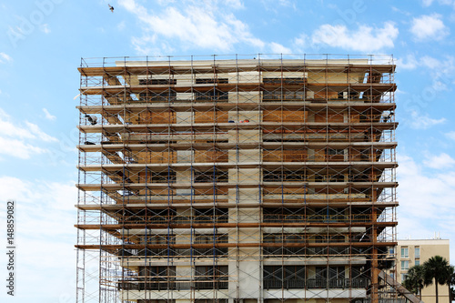 Old building facade under reconstruction with scaffolding