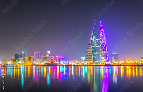 Skyline of Manama dominated by the World trade Center building during night, Bahrain. photo