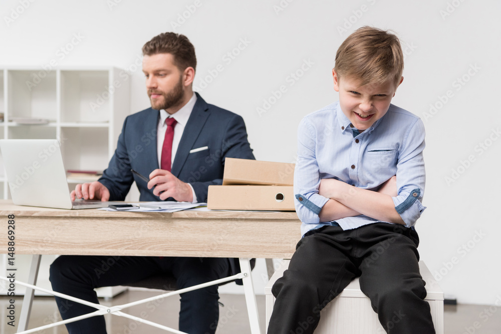 Naughty boy with his father businessman at office Naughty boy with his father businessman at office