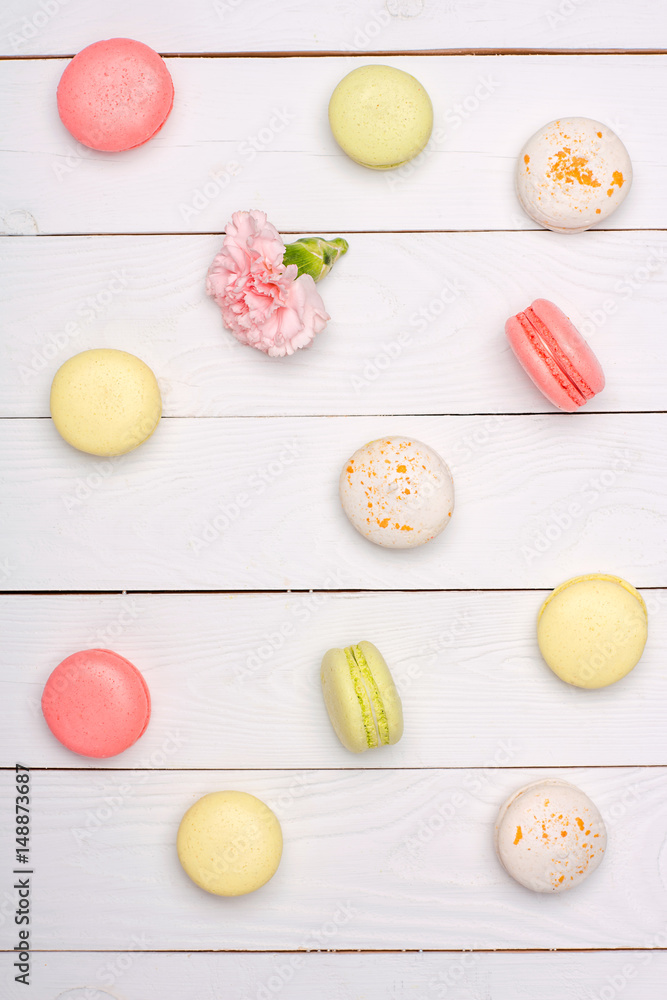 Variety of fresh macaroons in waffle cones on wooden surface. Colorful macarons pattern concept Variety of fresh macaroons in waffle cones on wooden surface. Colorful macarons pattern concept