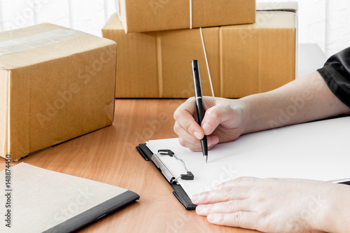 Woman signs clipboard for delivery