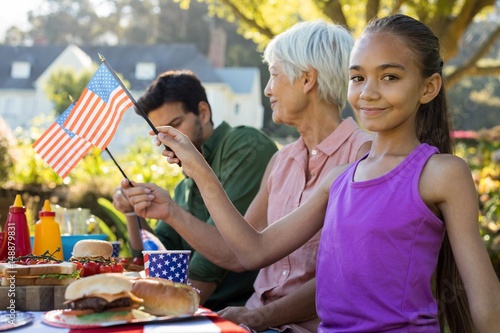 Girl holding American flag near the picnic table