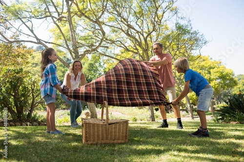 Family spreading the picnic blanket