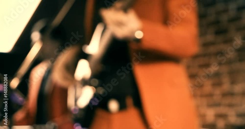 Rockabilly band having fun playing drums and guitar and singing in front of brick wall