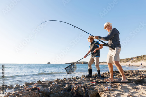 Senior man fishing with his grandson