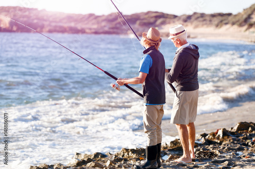 Senior man fishing with his grandson