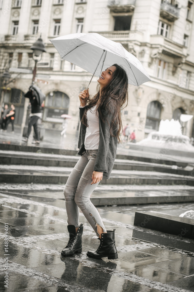 Happy smiling woman under umbrella in rain