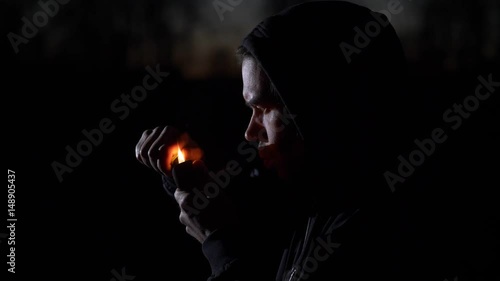 Smoking man in the dark. Slow motion.