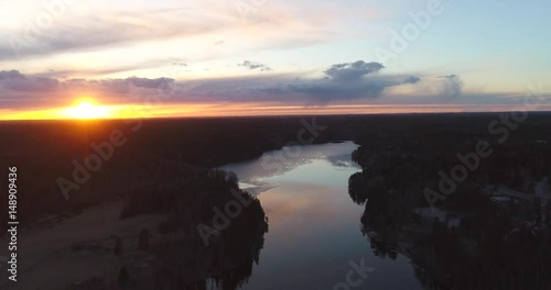 Pitkajarvi, Cinema 4k aerial backward flight above pitkajärvi, at a sunset, in nuuksio national park, on a sunny spring evening, in Espoo, Finland photo