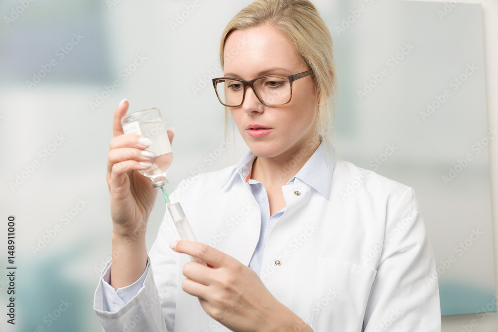 Junge hübsche Ärztin zieht Spritze auf Junge hübsche Ärztin zieht Spritze auf