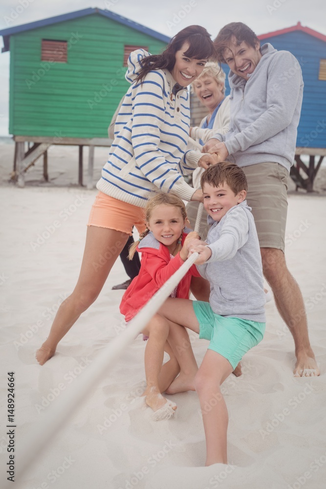 Fototapeta premium Happy multi-generation family playing tug of war