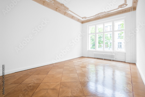 Empty room with parquet floor and stucco ceiling - new renovated flat in old building