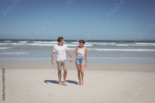 Full length of couple holding hands at beach