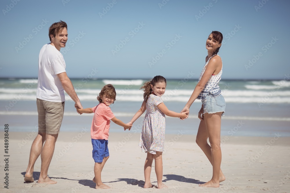 Portrait of happy family holding hands at beach