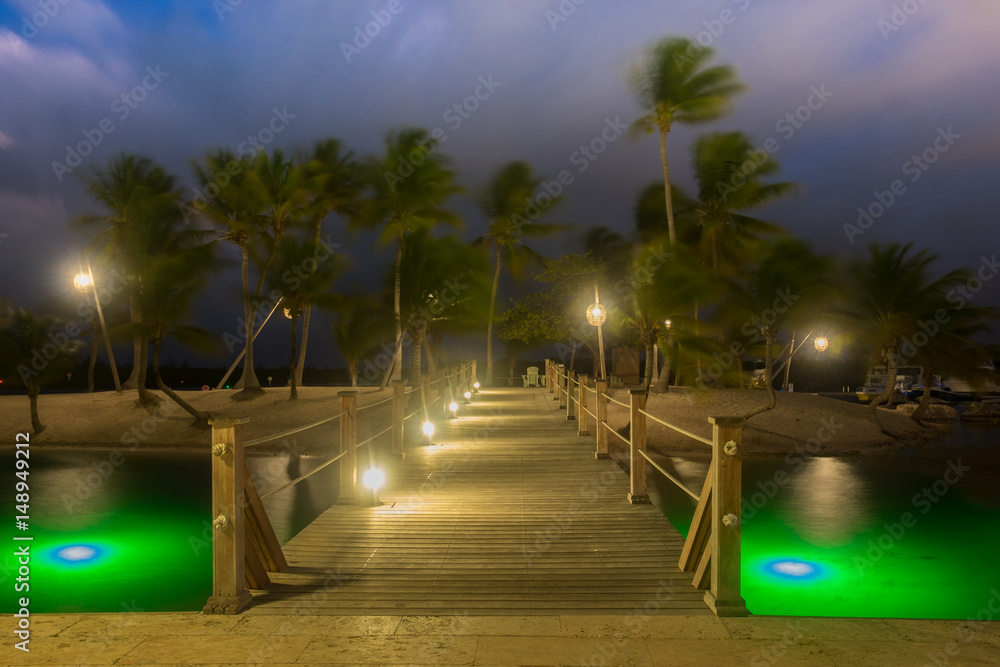 Wooden bridge at Camana Bay spanning over the Caribbean Sea leading to