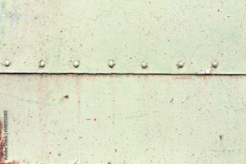 Rusty metal plate surface with rivets.
