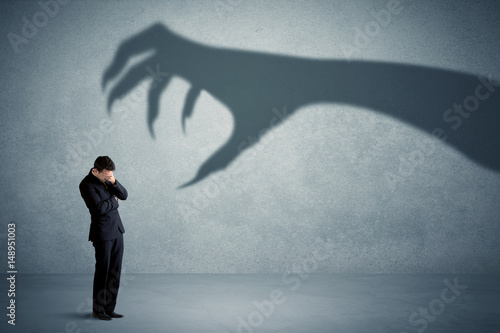 Obraz na płótnie Business person afraid of a big monster claw shadow concept w salonie