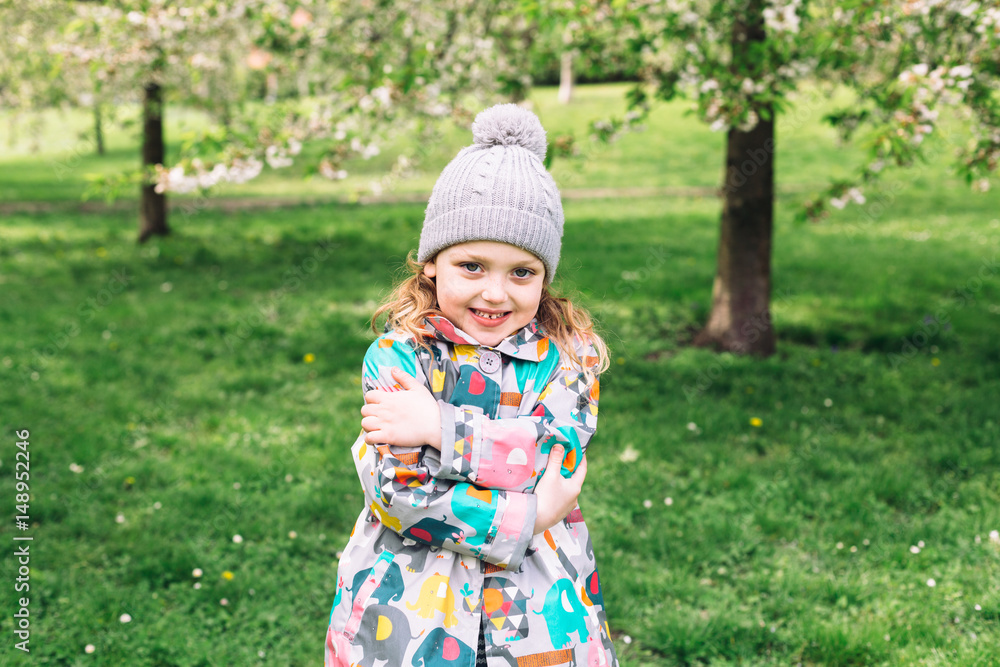 Cute smiling little girl playing in spring blossoming garden. Kid plays outdoors. Cute smiling little girl playing in spring blossoming garden. Kid plays outdoors.