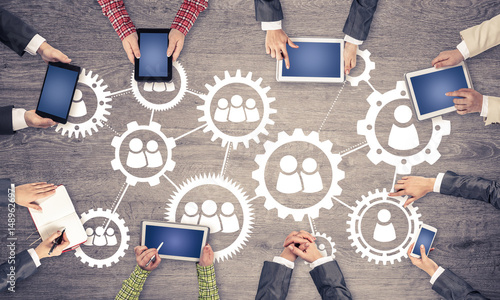 Top view of businesspeople sitting at table and using gadgets