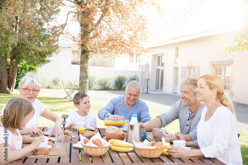 Family of 6 having breakfast together outside the house