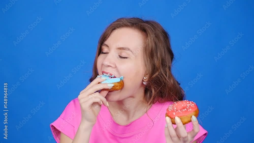 Young beautiful eating donut. Overeating concept Young beautiful eating donut. Overeating concept