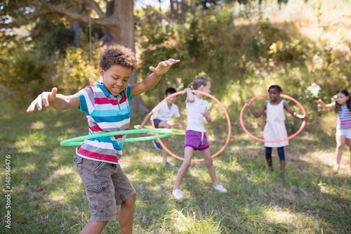 Tablou pe pânză Group of friends enjoying with hula hoops at campsite