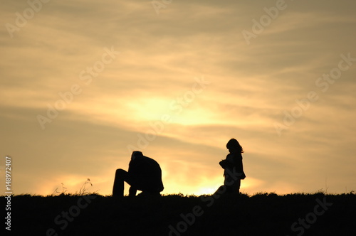 Vater mit Kind auf dem Damm im Sonnenuntergang